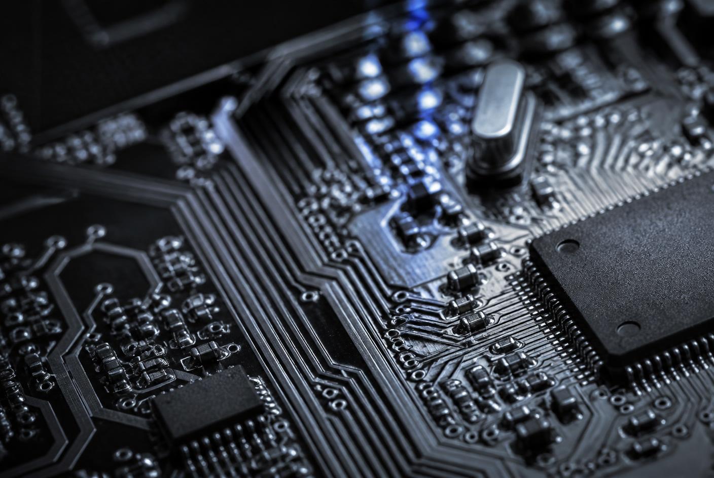 Close-up of electronic components and conductive traces on a dark circuit board